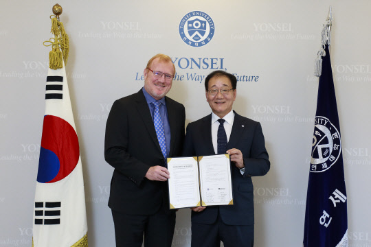 8일 서울 신촌동 연세대에서 김용학 연세대 총장(오른쪽)과 피터 무어 AWS 아시아태평양 공공 총괄이 협약을 체결하고 기념촬영을 하고 있다.  AWS코리아 제공